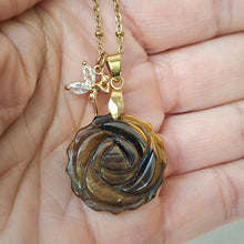 Charger l'image dans la galerie, Collier en œil de tigre sculpté en rose présenté dans la main.
