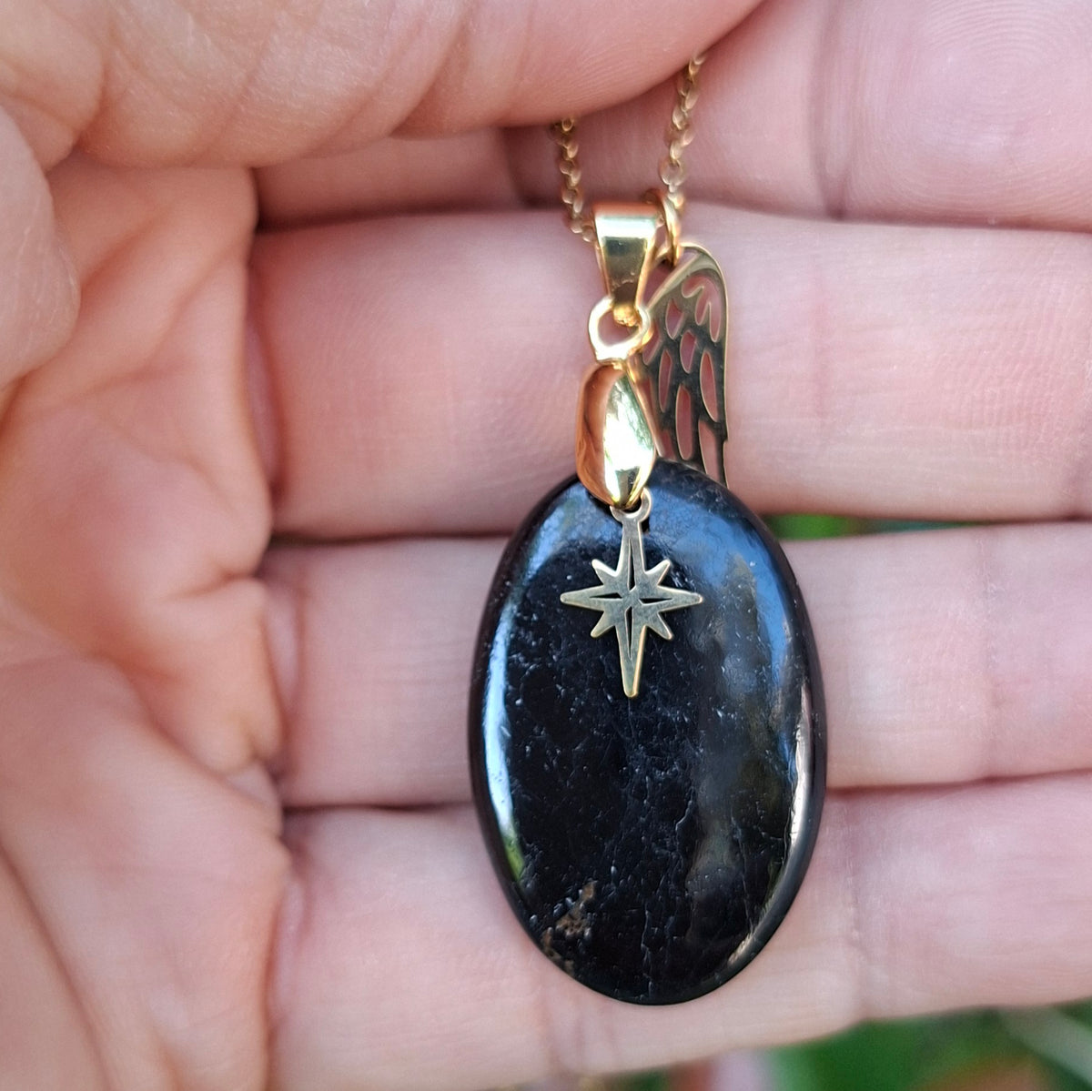Collier en tourmaline ovale présenté dans la main.
