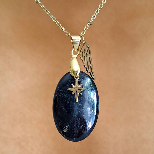 Collier en tourmaline noire ovale aux reflets profonds avec breloques étoile et aile dorées.
