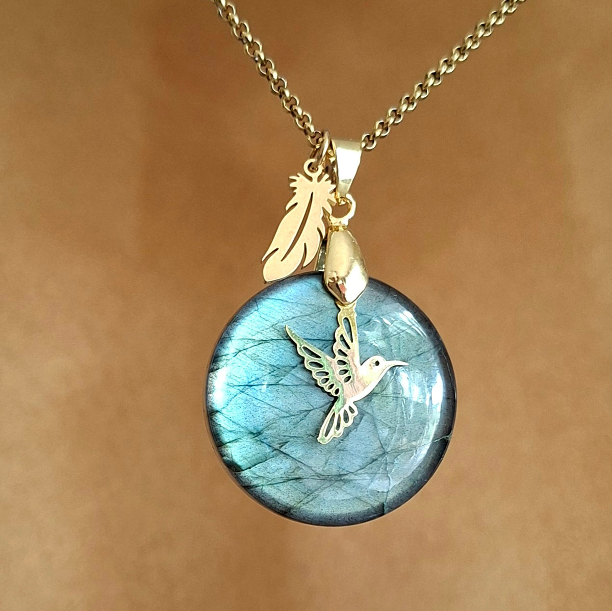 Collier en labradorite ronde aux reflets verts avec breloque colibri et plume.