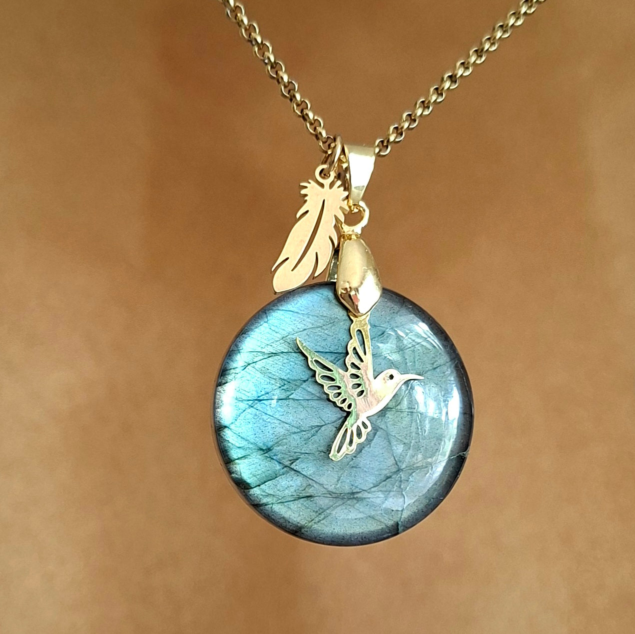 Collier en labradorite ronde aux reflets verts avec breloque colibri et plume.