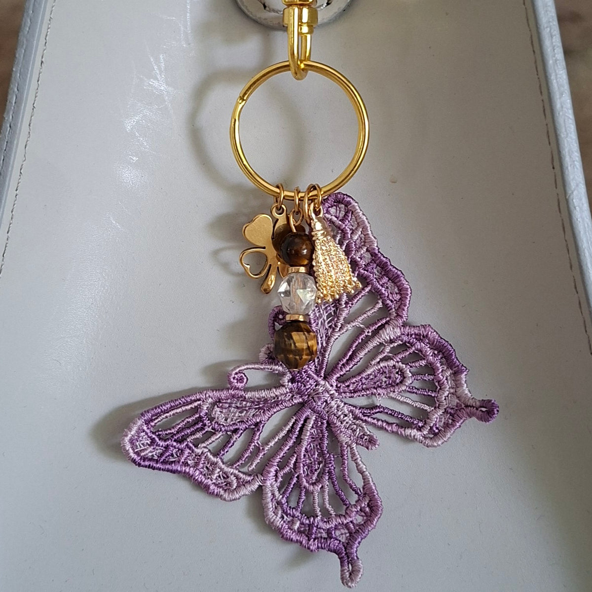 Grigri de sac Papillon artisanal accroché à un sac blanc