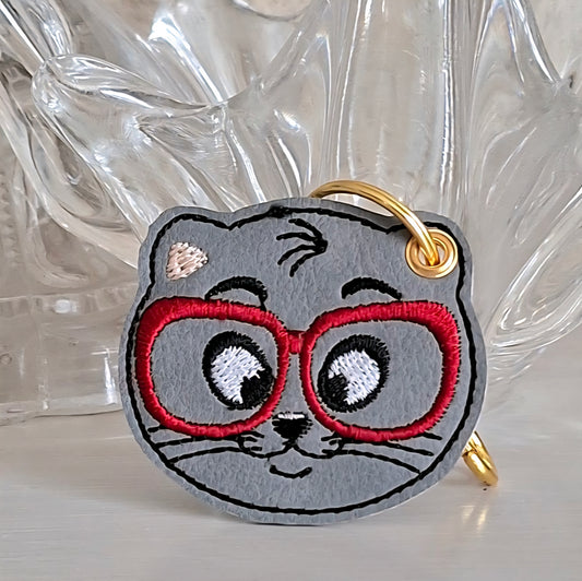 Porte clé chat brodé sur simili-cuir, petit compagnon à lunettes rouges