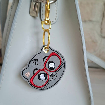 Porte clés chat brodé sur simili-cuir accroché à un sac