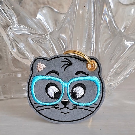 Porte clés chat à lunettes bleues brodé sur simili cuir