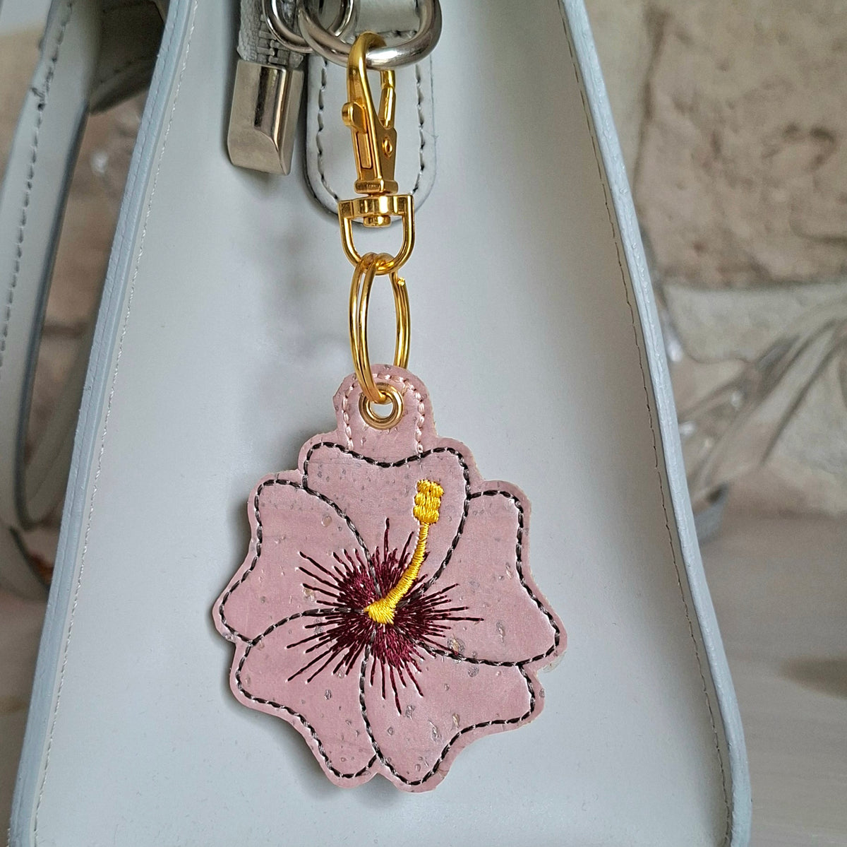 Porte-clés hibiscus brodé sur liège avec attache métal doré sur un sac