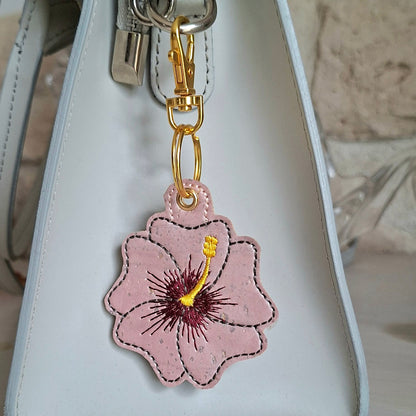 Porte-clés hibiscus brodé sur liège avec attache métal doré sur un sac