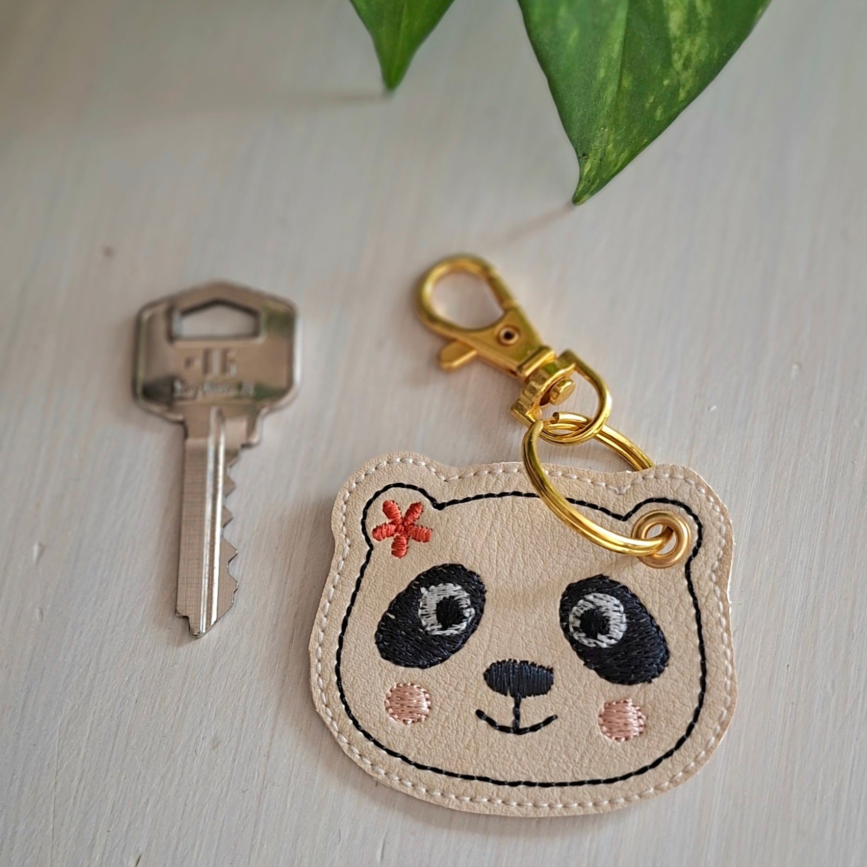 Détail du porte-clés panda brodé sur simili-cuir, fabrication artisanale
