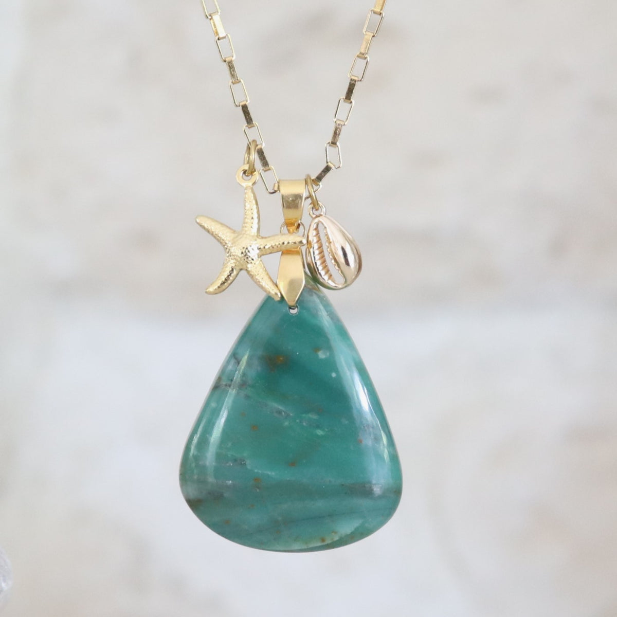 Collier en jaspe vert naturel taillé en forme de poire, sur chaîne dorée.