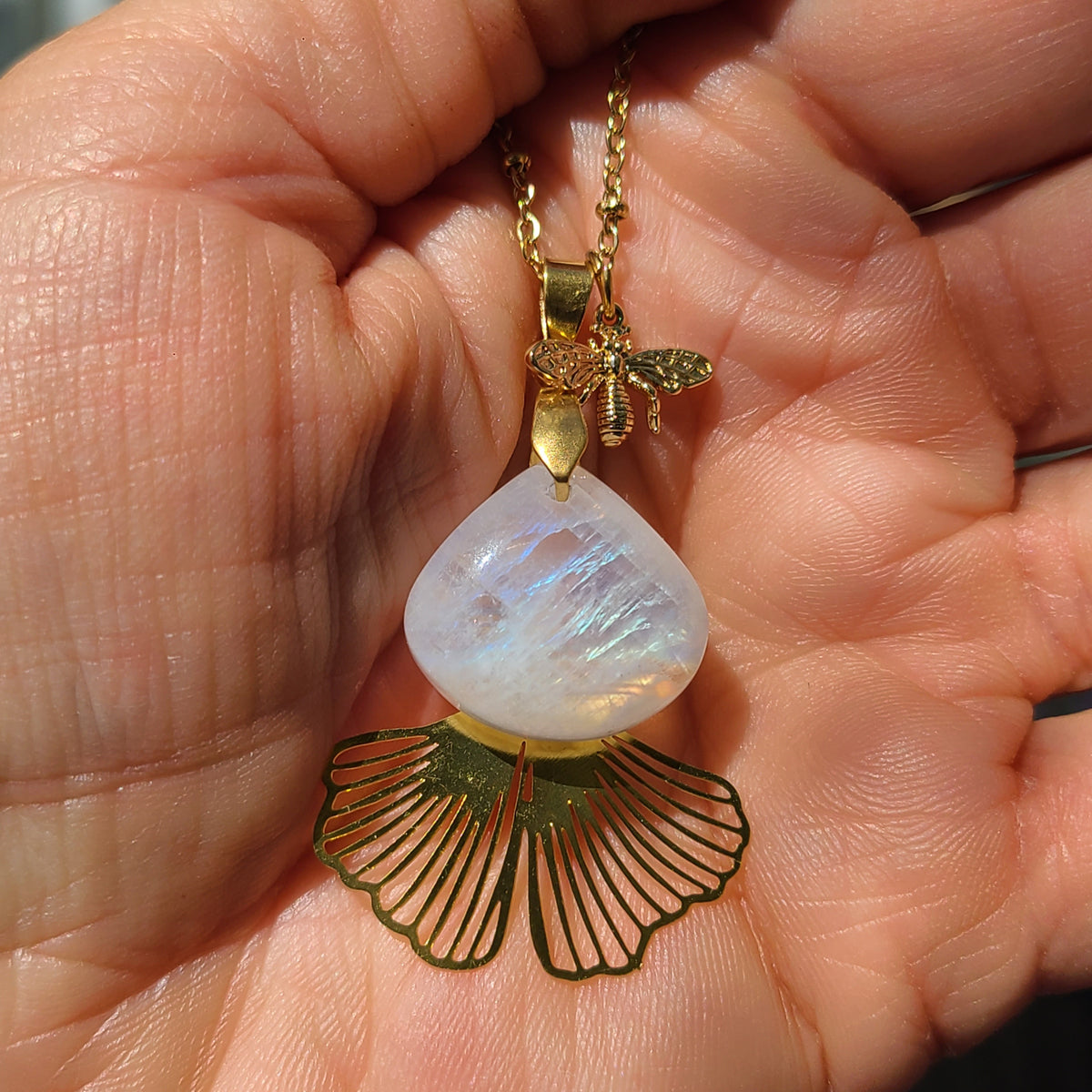 Collier acier en pierre de lune détail dans une main