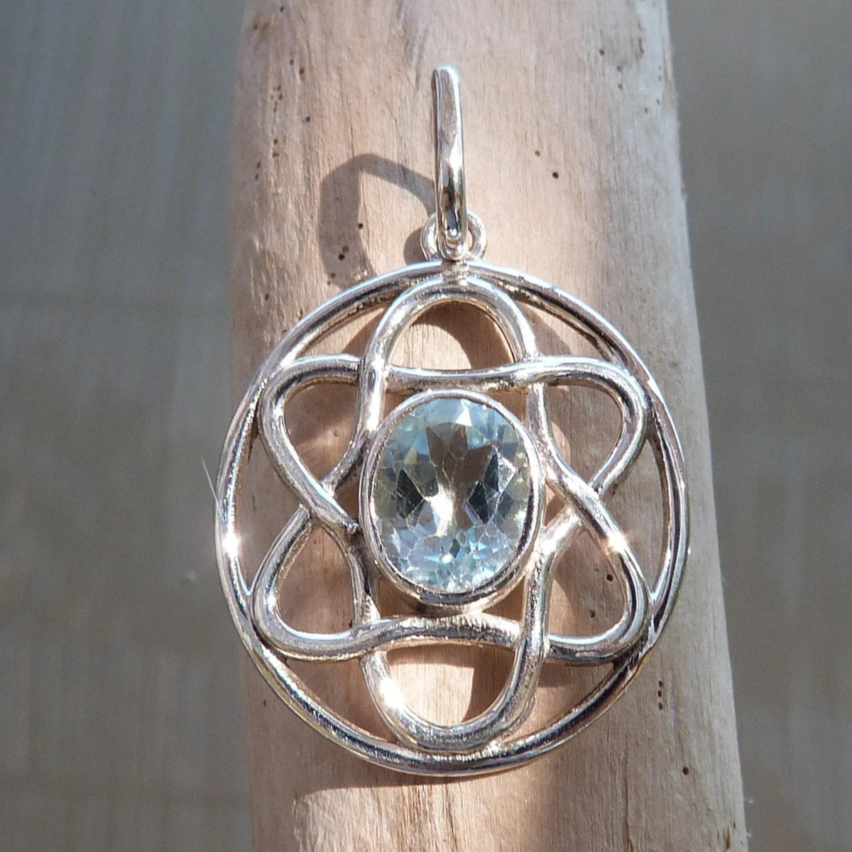 Pendentif fleur en argent avec topaze bleue facettée. 